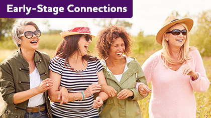 Four women linking arms and laughing