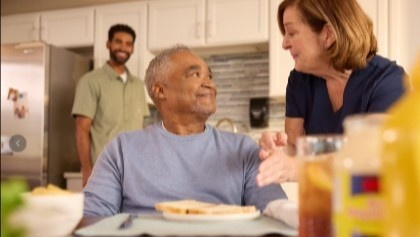Respite resident having breakfast served by a care provider 