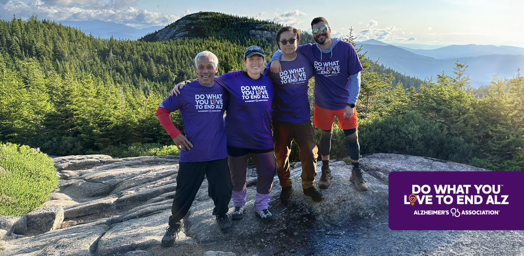 Four men are at the top of a mountain with the mountain range in the background. On the left a headline reads Do What You Love to End ALZ