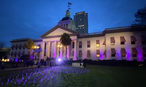 The Florida State Capitol building lit in purple