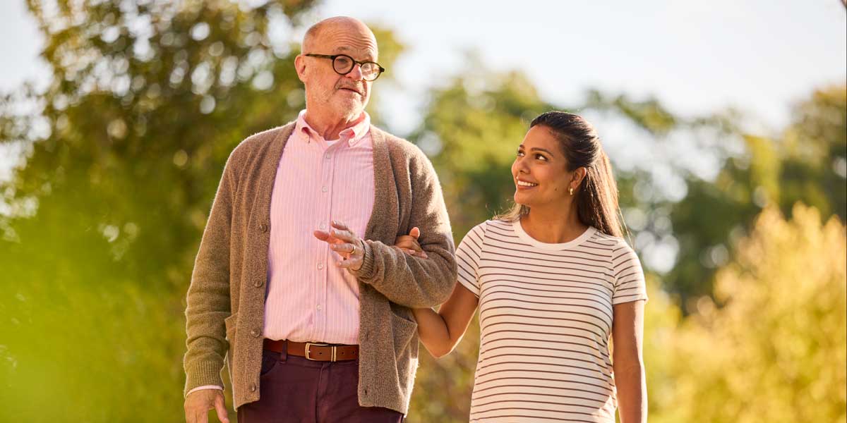 Caregiver walks with a person living with Alzheimer's