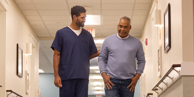 Caregiver walks with a person living with dementia