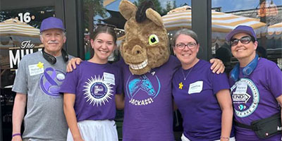 A group of volunteers poses with a donkey mascot