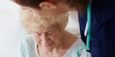 Elderly individual in conversation with a healthcare professional, illustrating compassionate care in Alzheimer’s dementia support.