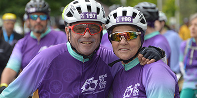 Two people in Alzheimer's Association cycling gear smile at the camera.