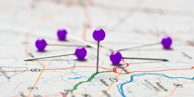 Paper map with purple push pins marking travel routes, symbolizing planning and navigation in Alzheimer’s dementia support.