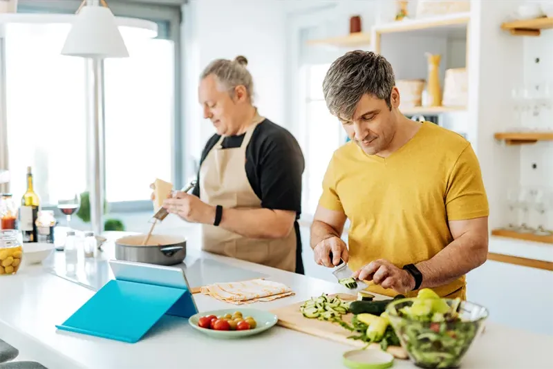 Two people preparing food in ktichen