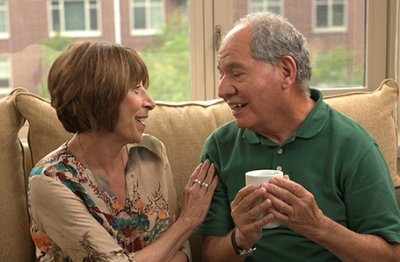 A senior couple speaks with each other on the couch