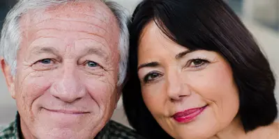 Close-up of two older adults smiling gently at the camera, reflecting connection and warmth in Alzheimer’s dementia support.