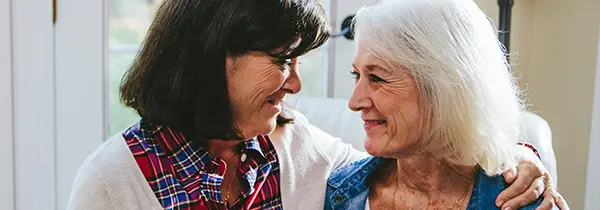 Two older adults sharing a warm moment together indoors, reflecting connection and care in Alzheimer’s dementia support.