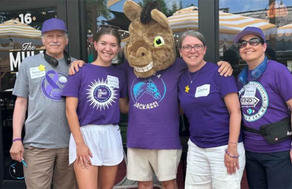 Volunteers stand with a donkey mascot