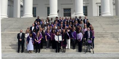 A group of advocates stand on the steps of the Virginia State Capitol