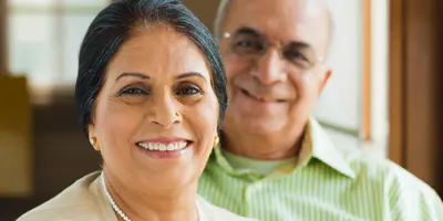 Two older adults smiling indoors, reflecting warmth and connection in Alzheimer’s dementia support.