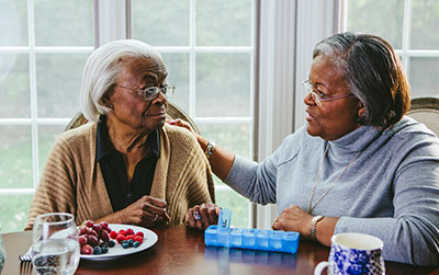 Two women with gray hair talking to each other.