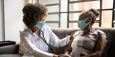 Image of a Black doctor providing care to patient