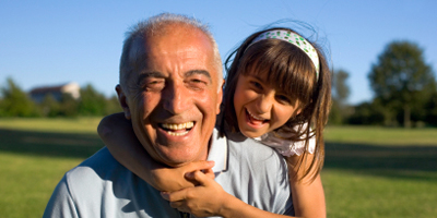 Granddaughter hugging laughing grandfather