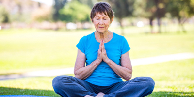 Woman sitting outdoors in a tranquil yoga position