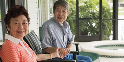 An older Asian woman holding hands with a younger Asian woman